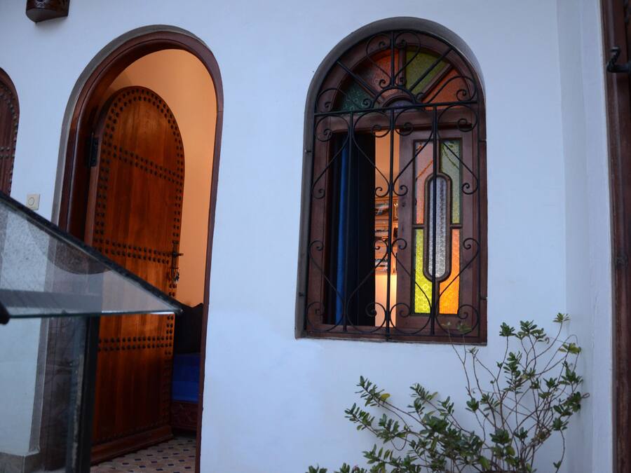 A building entrance with a wooden door and a window with decorative iron bars.