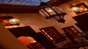 A room with ornate lanterns, wooden arches, and a skylight. - Dar Rehla (Tetouan)