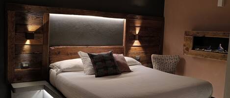 A modern bedroom with a large bed, wooden headboard, and built-in nightstands.