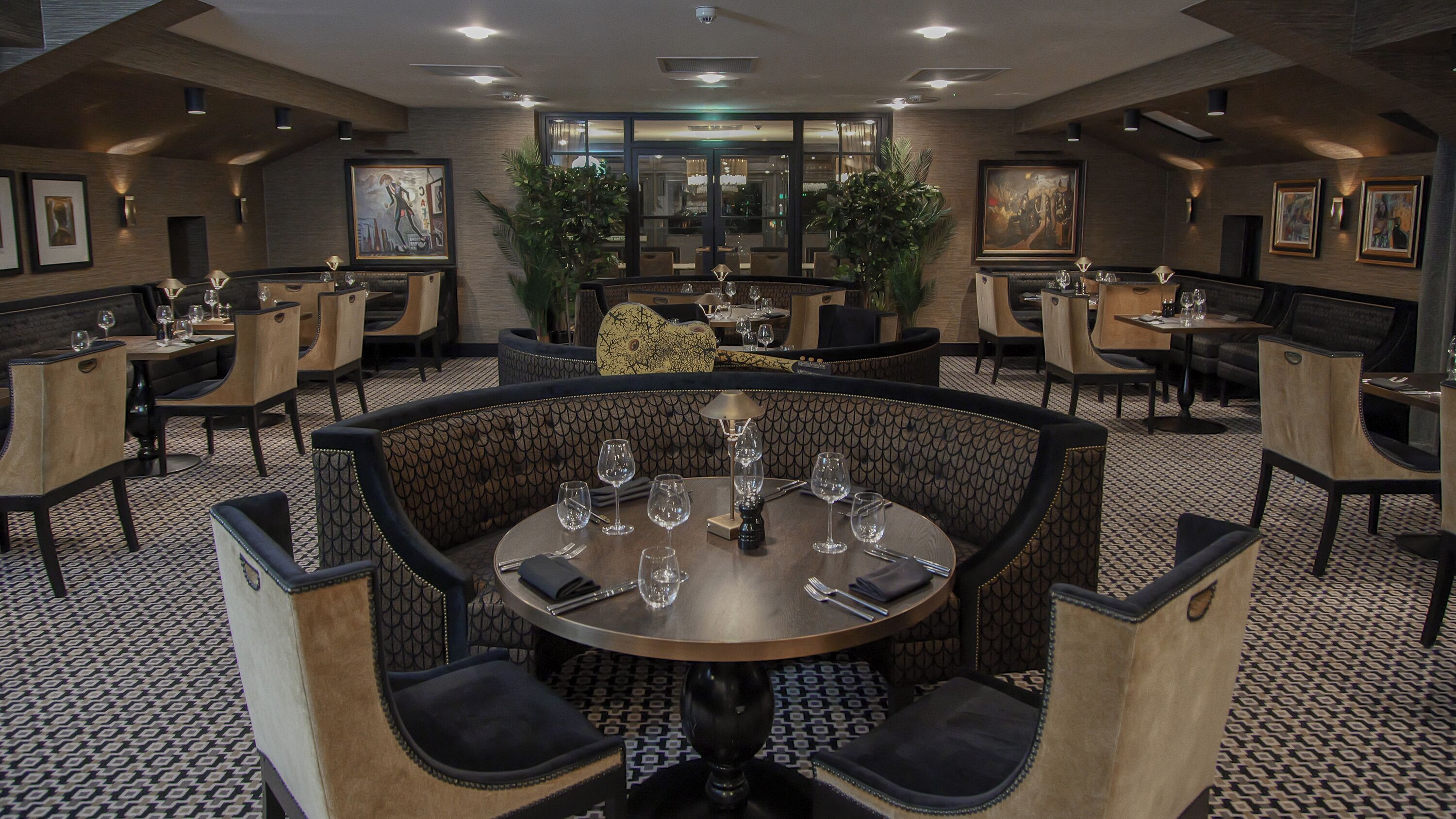 A restaurant with round tables, chairs, and a patterned floor.