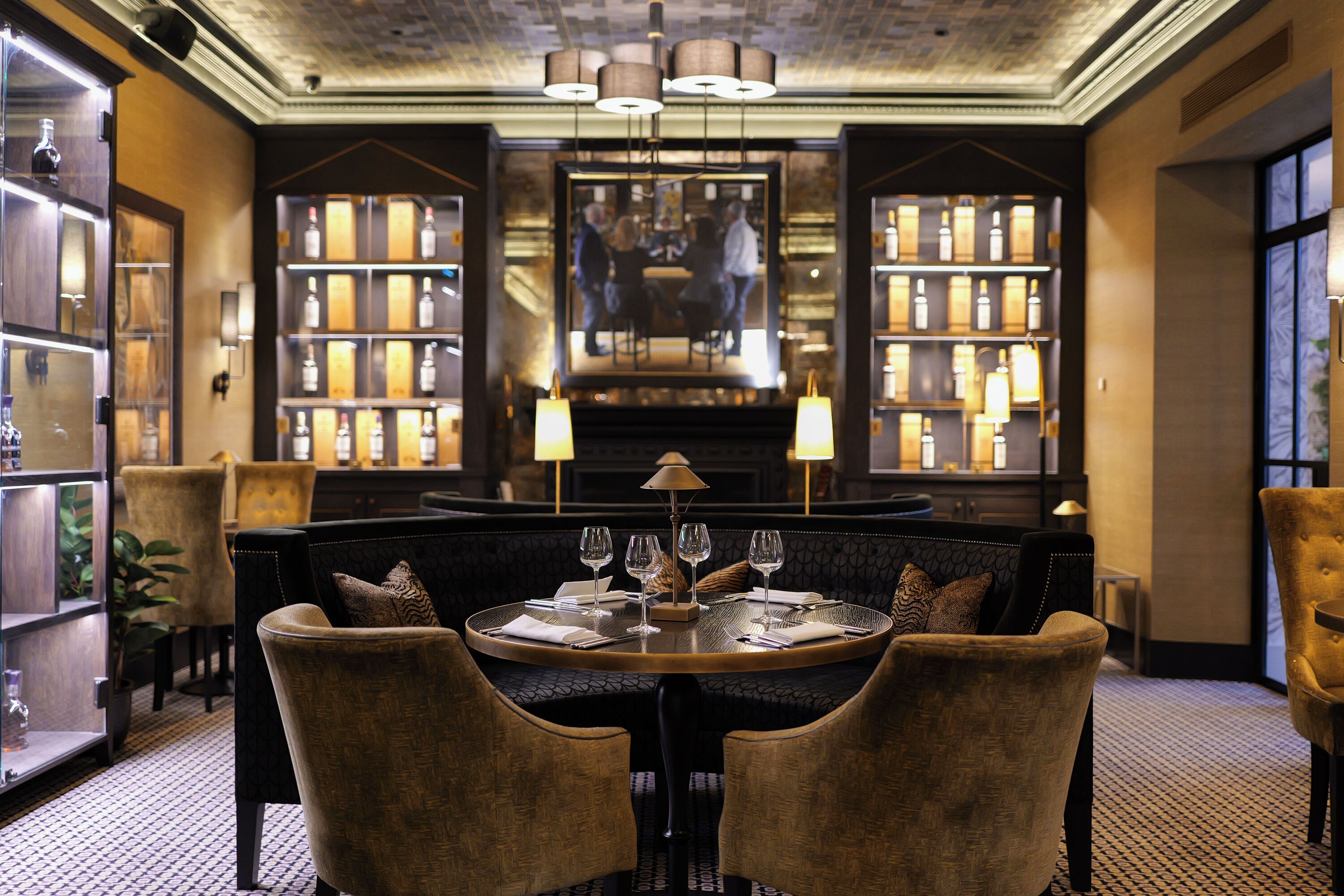 A dining area with a round table, chairs, and a chandelier.