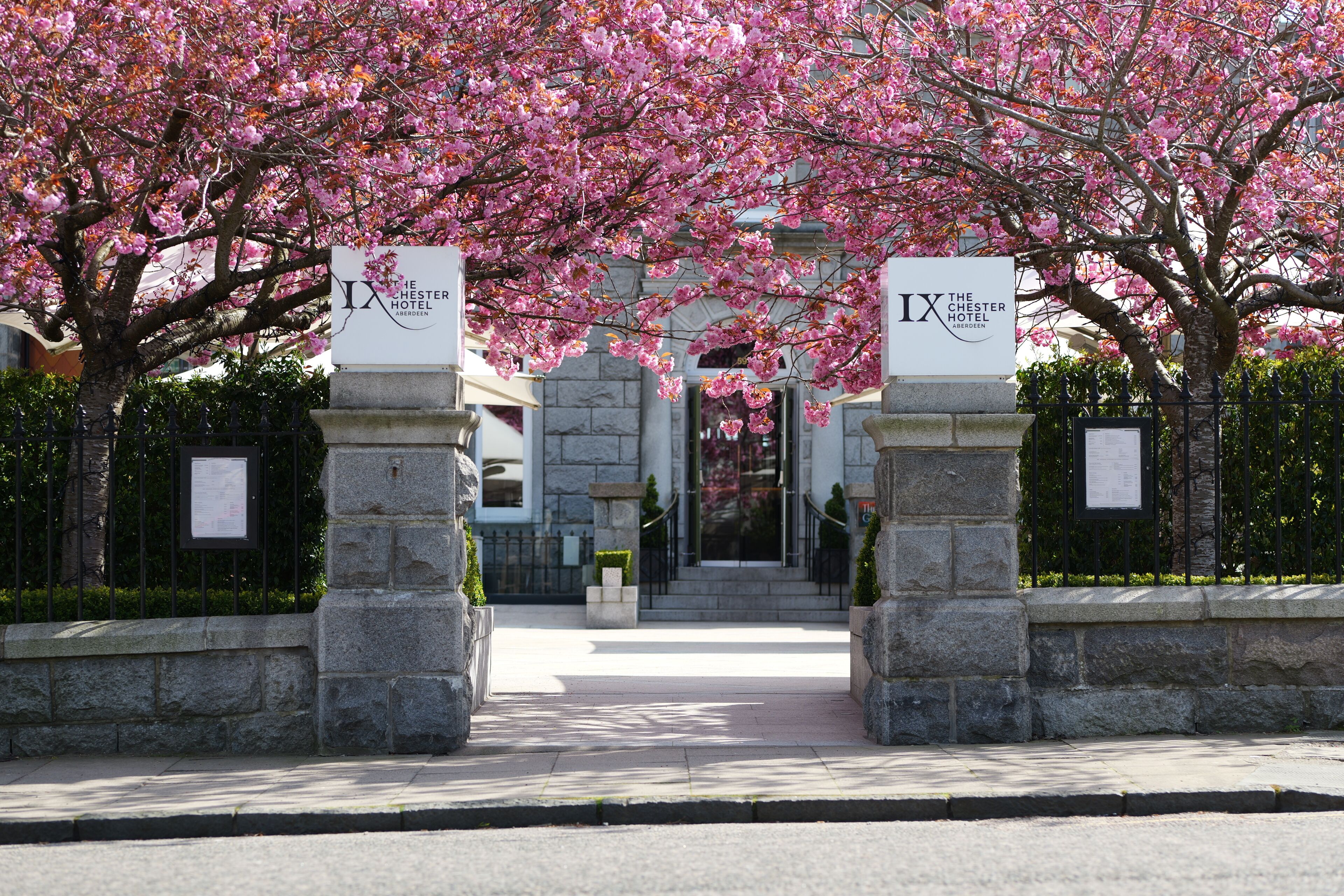 The entrance to The Chester Hotel Aberdeen, featuring stone pillars and a pathway leading to the entrance.