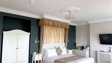 A neatly arranged bedroom with a bed, bedside tables, a wardrobe, a television, and a chandelier.