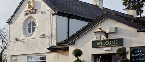 A building with a 'Welcome' sign, a 'Bar & Reception' sign, and a 'Hungry Horse' sign.