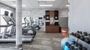 A gym with treadmills, ellipticals, and free weights.