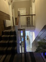 Una escalera con barandilla de madera y balaustrada blanca, que conduce a un piso superior.