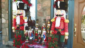 A nutcracker display with nutcracker figures and bottles, placed in front of a stone wall and a wooden door.