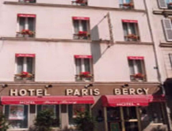 Un edificio de varios pisos con un letrero que dice "HOTEL PARIS BERCY".
