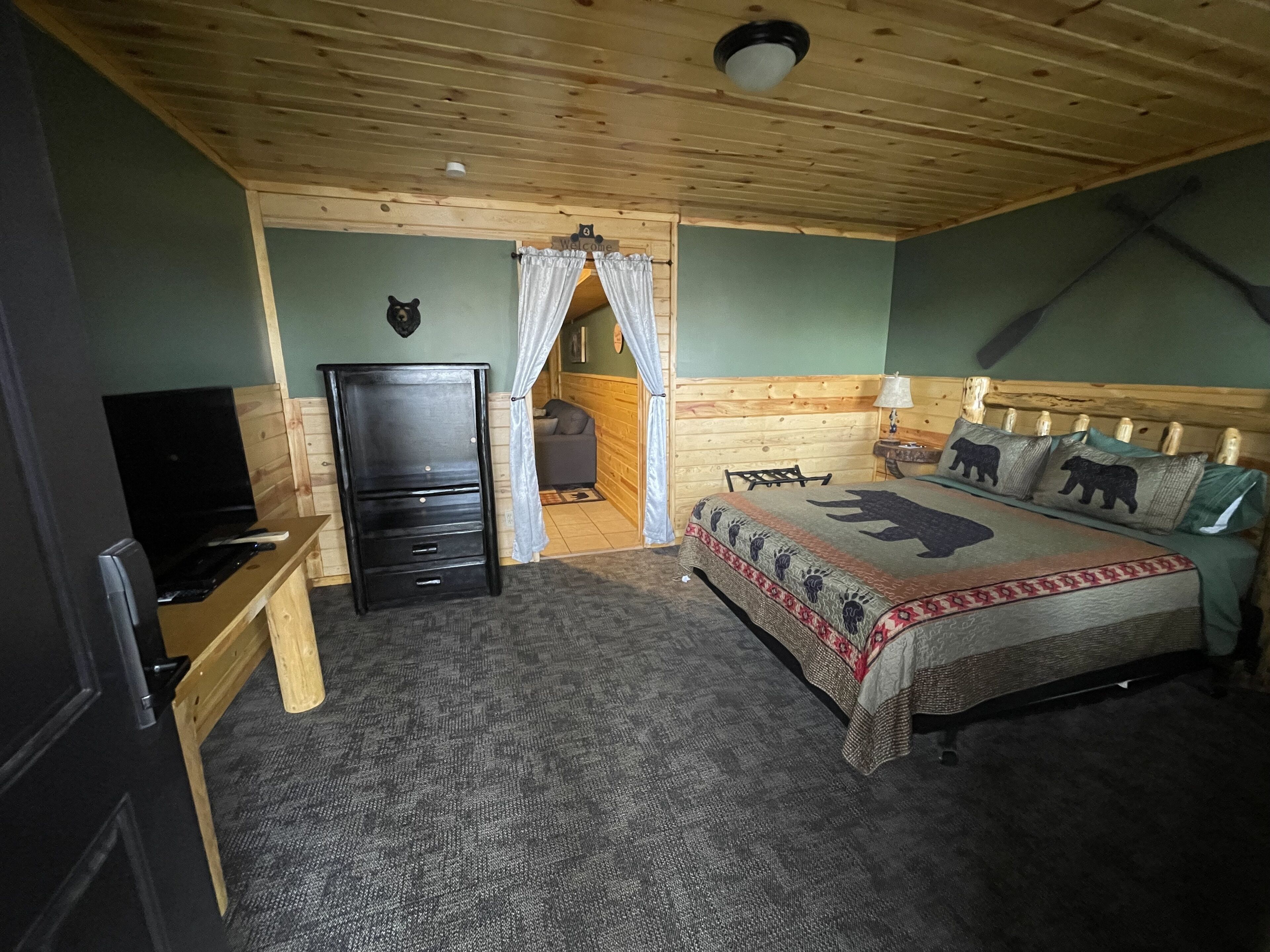 Un dormitorio con cama, escritorio, televisor y armario.