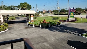 A hotel entrance with a landscaped garden, a fountain, and a sign for Sun Inn & Suites. - Sun Inn & Suites (Kissimmee)