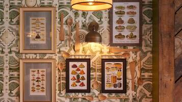 A wall with framed food illustrations and wooden spoons.