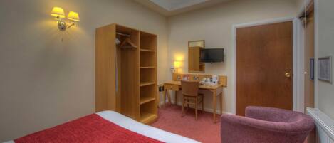 A hotel room with two beds, a desk, a chair, a wardrobe, a television, and a door.