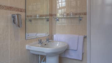 A bathroom with a bathtub, sink, and mirror.