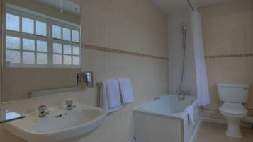 A bathroom with a sink, mirror, bathtub, shower, and toilet.