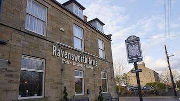 Un bâtiment en pierre sur lequel on peut lire l’inscription suivante : « Ravensworth Arms, pub, restaurant, chambres ».