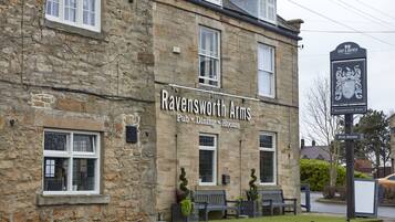 A stone building with the sign "Ravensworth Arms Pub, Dining, Rooms".