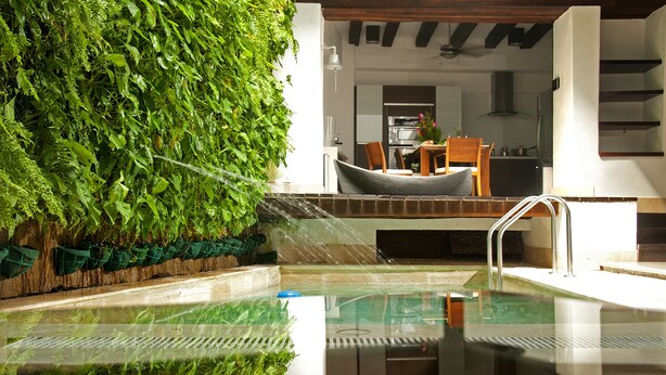 A swimming pool with a glass bottom, surrounded by lush greenery and a wooden deck. - Casa Gastelbondo By Vistamarina - Adults Only (Cartagena)