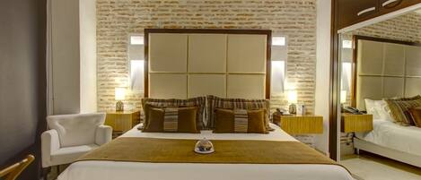 Un dormitorio con una cama grande, techo de madera y pared de piedra.