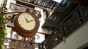 A rustic outdoor clock with Roman numerals, mounted on a metal structure with decorative elements. - Casa Gastelbondo By Vistamarina - Adults Only (Cartagena)