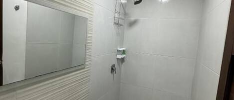 A modern bathroom with a sink, toilet, and shower.