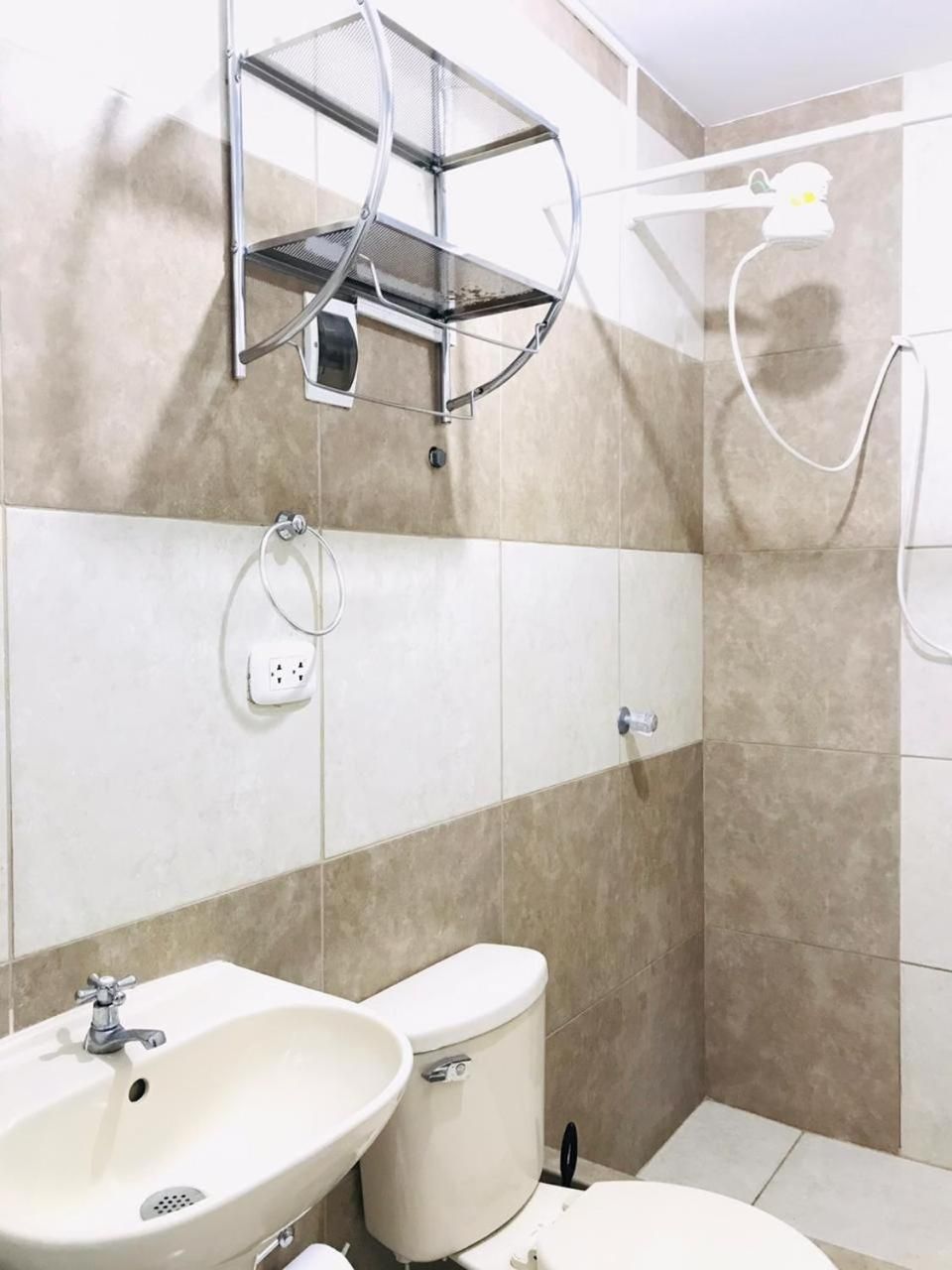 Un baño con lavamanos, inodoro y ducha.