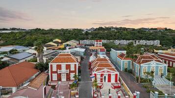 Vista da rua de uma cidade com edifícios, uma área de recepção e uma placa com 'Dushi'.