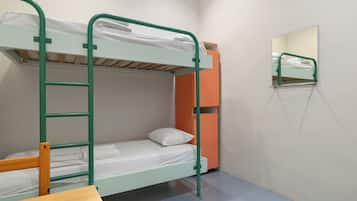 Een stapelbed met een ladder, een tafeltje en een spiegel aan de muur.