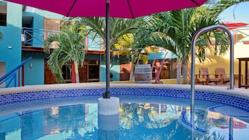 Relax by the pool surrounded by lush palm trees and vibrant architecture.