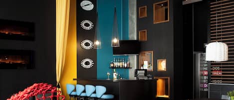 Un bar moderno con barra, taburetes y una zona de estar con una estructura de red roja.