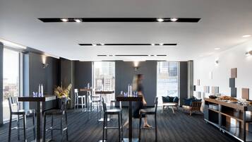 Un espacio de oficina moderno con comedor, ventanas amplias y vistas a la ciudad.