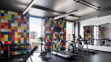 A gym with treadmills, elliptical machines, and dumbbells.