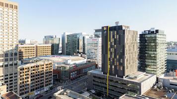 A modern hotel with a prominent vertical design, surrounded by other high-rise buildings and a busy urban street.
