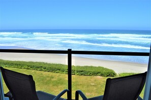 A balcony with a view of the ocean and beach.