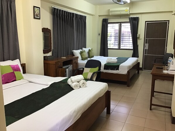 A hotel room with two beds, a desk, a chair, a mirror, and a window with curtains. - Saithong House (Chiang Mai)