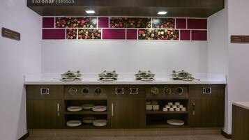 A kitchen with a white countertop, wooden cabinets, and a backsplash with floral patterns.