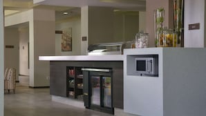 A modern hotel lobby with a self-service snack bar, refrigerated display cases, and a microwave. - Hampton Inn by Hilton Zacatecas (Zacatecas)