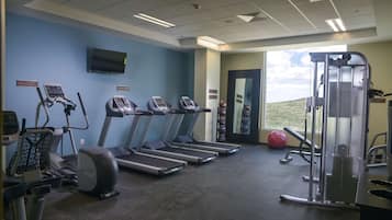 A gym with treadmills, an elliptical, and a weight machine.