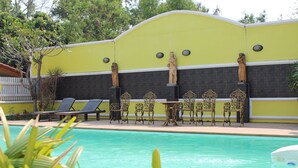 A pool area with lounge chairs and a statue. - Sangthong Resort (Saraphi)