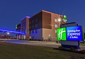 A Holiday Inn Express & Suites building with a prominent sign, a parking lot, and a well-lit entrance. - Holiday Inn Express & Suites Tulsa West - Sand Springs by IHG (Sand Springs)