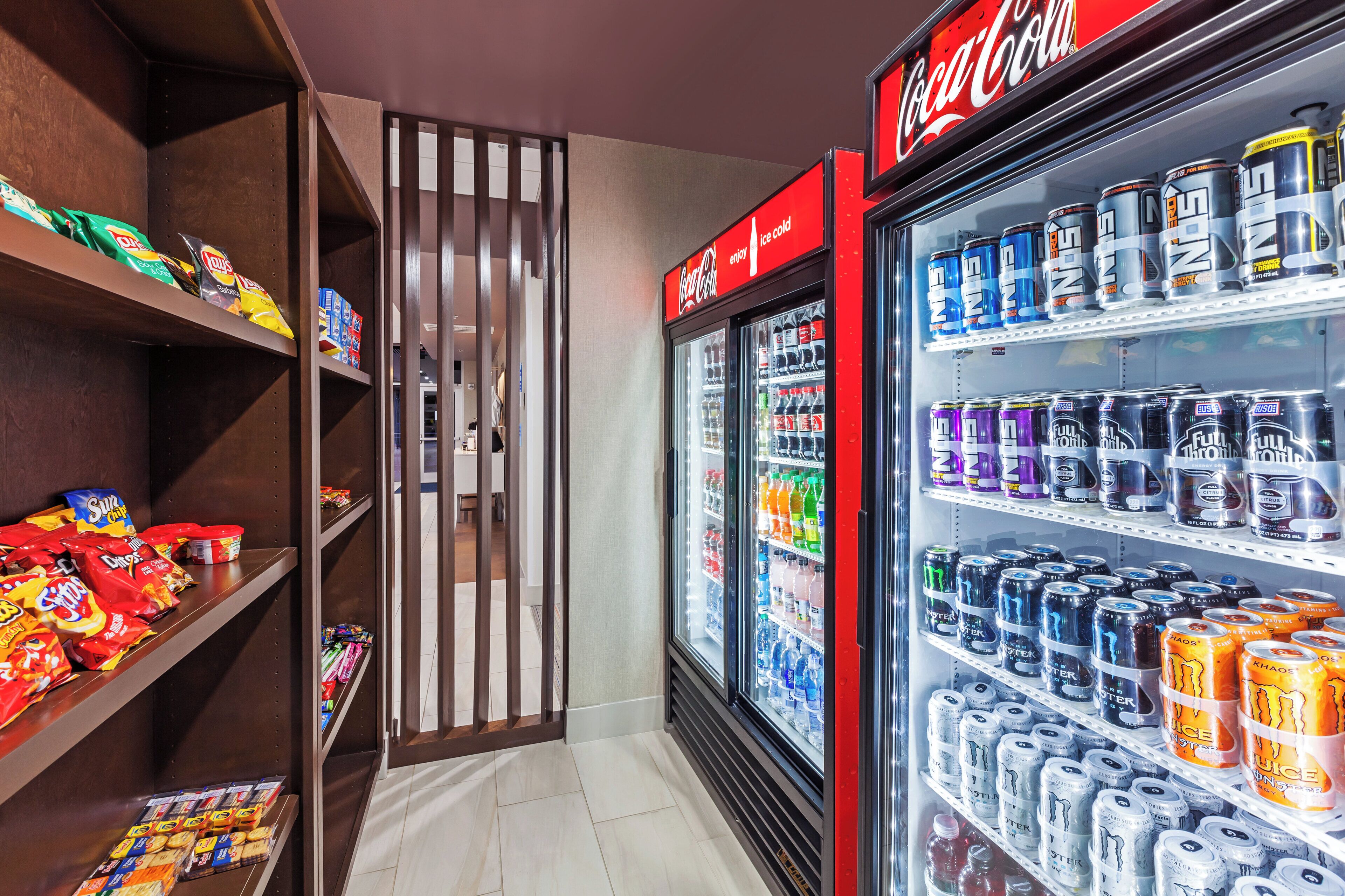 A vending area with snacks and beverages, including Coca-Cola and Monster energy drinks.