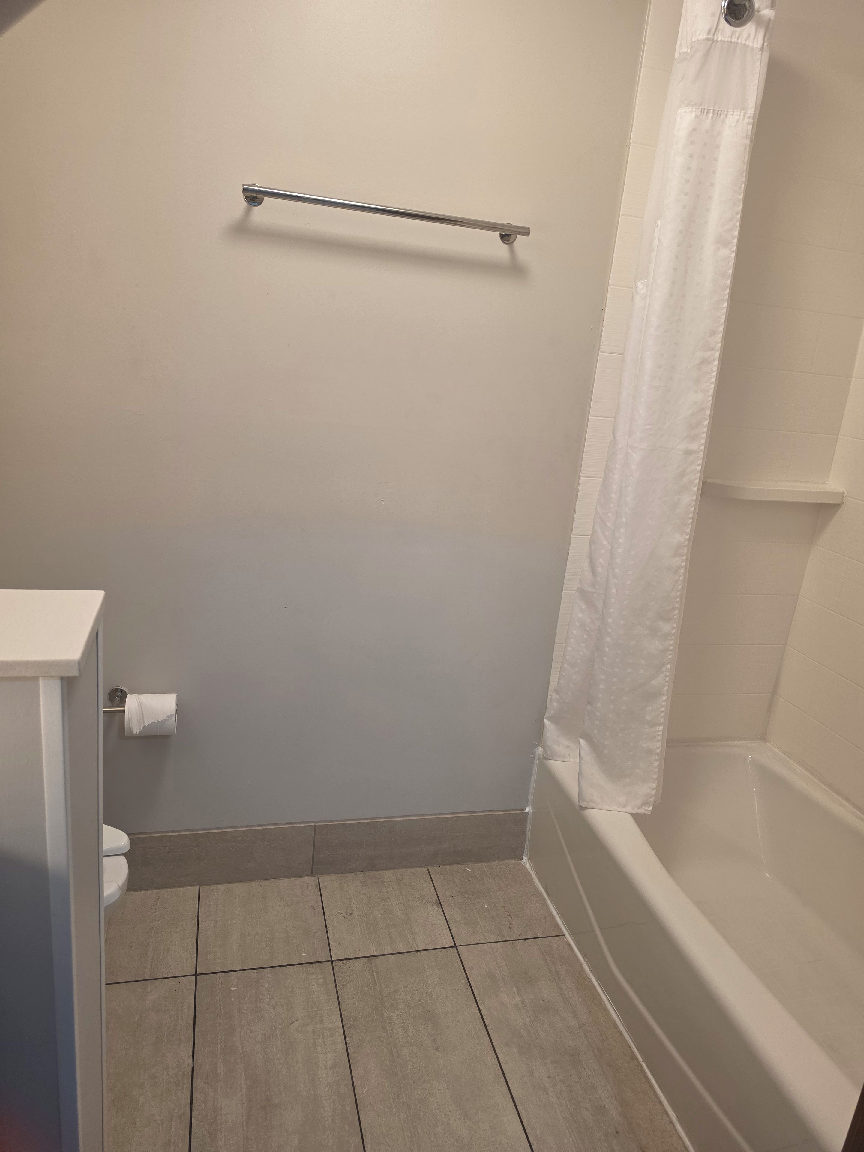 Un baño con inodoro, toallero y bañera.