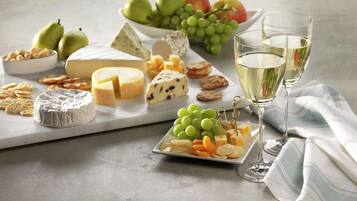 A cheese board with various cheeses, grapes, and crackers.