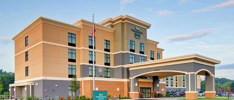 A multi-story hotel with a prominent entrance and a sign for Homewood Suites by Hilton.