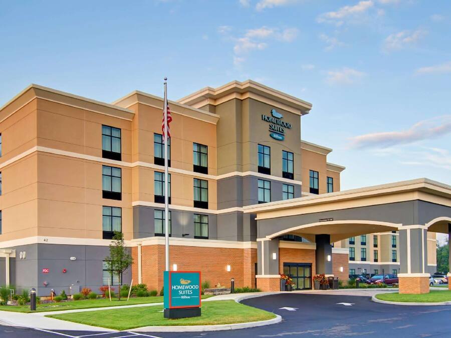 A multi-story hotel with a prominent entrance and a sign for Homewood Suites by Hilton.