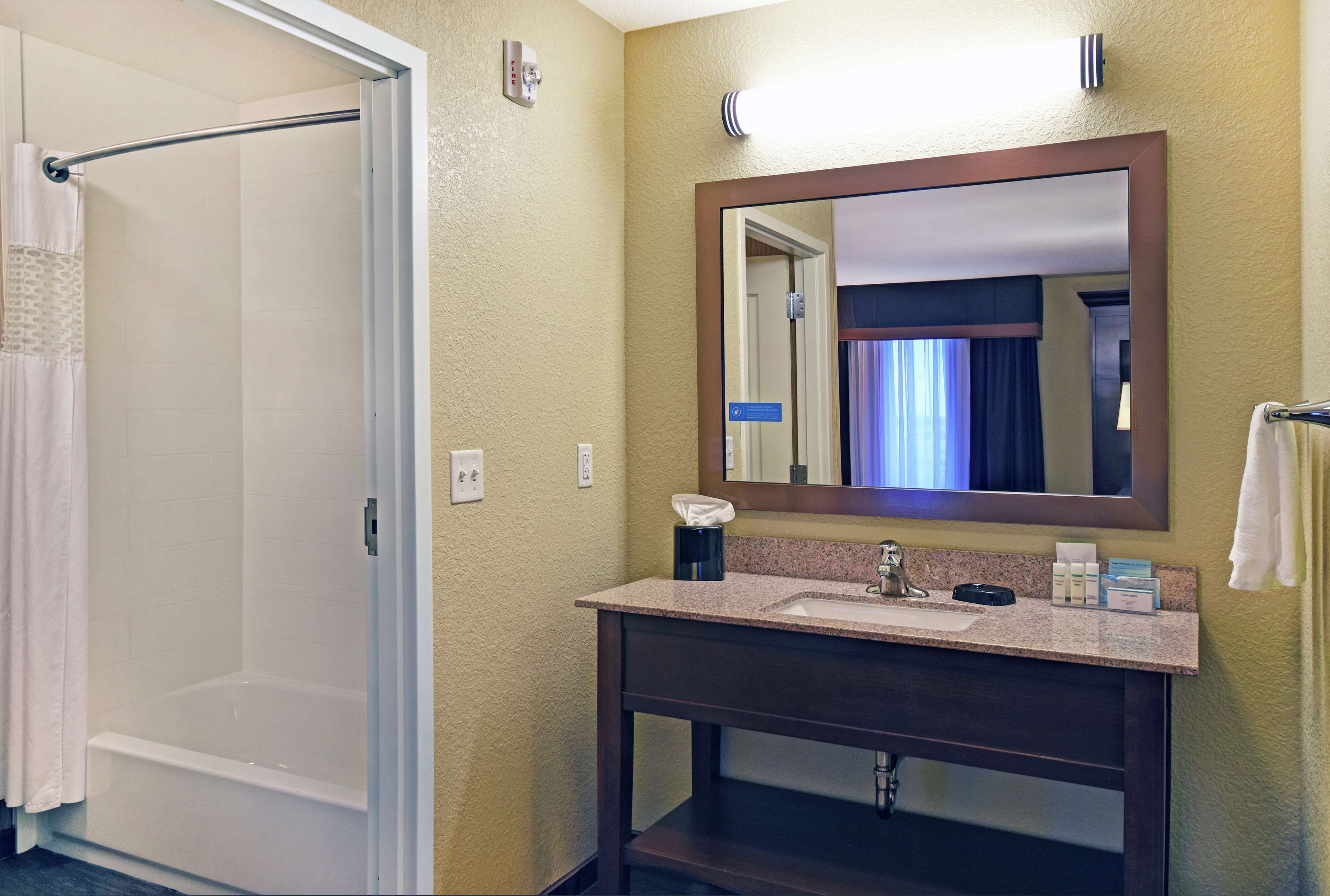 Une salle de bain équipée d’une douche, d’un lavabo, d’un miroir et d’un porte-serviettes.