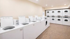 A laundry facility with multiple washing machines and dryers, arranged in a row. - Extended Stay America Select Suites - Atlanta - Chamblee (Chamblee)