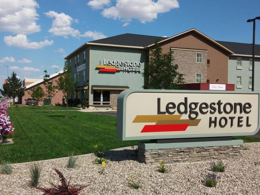 A hotel sign with the name 'Ledgestone Hotel' and a 'Now Open' sign above it.