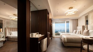 A modern hotel room with a large bed, a sofa, a desk, and a balcony with a view. - The Siena PRIMO (Seogwipo)