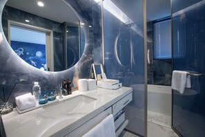 Een aparte badkuip en douche, designer toiletartikelen, een haardroger