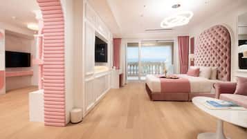 A modern hotel room with a large bed, a seating area, and a balcony with a view.